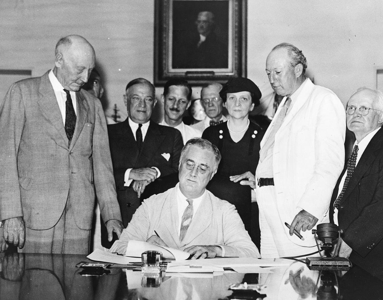 Le président Roosevelt, entouré de ses conseillers, signe le décret instituant la sécurité sociale aux États-Unis le 14 août 1935